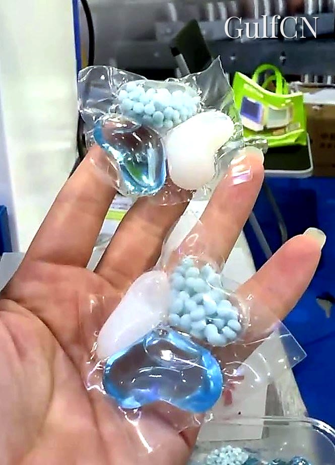 Three-chamber water-soluble detergent pod held at a China trade fair